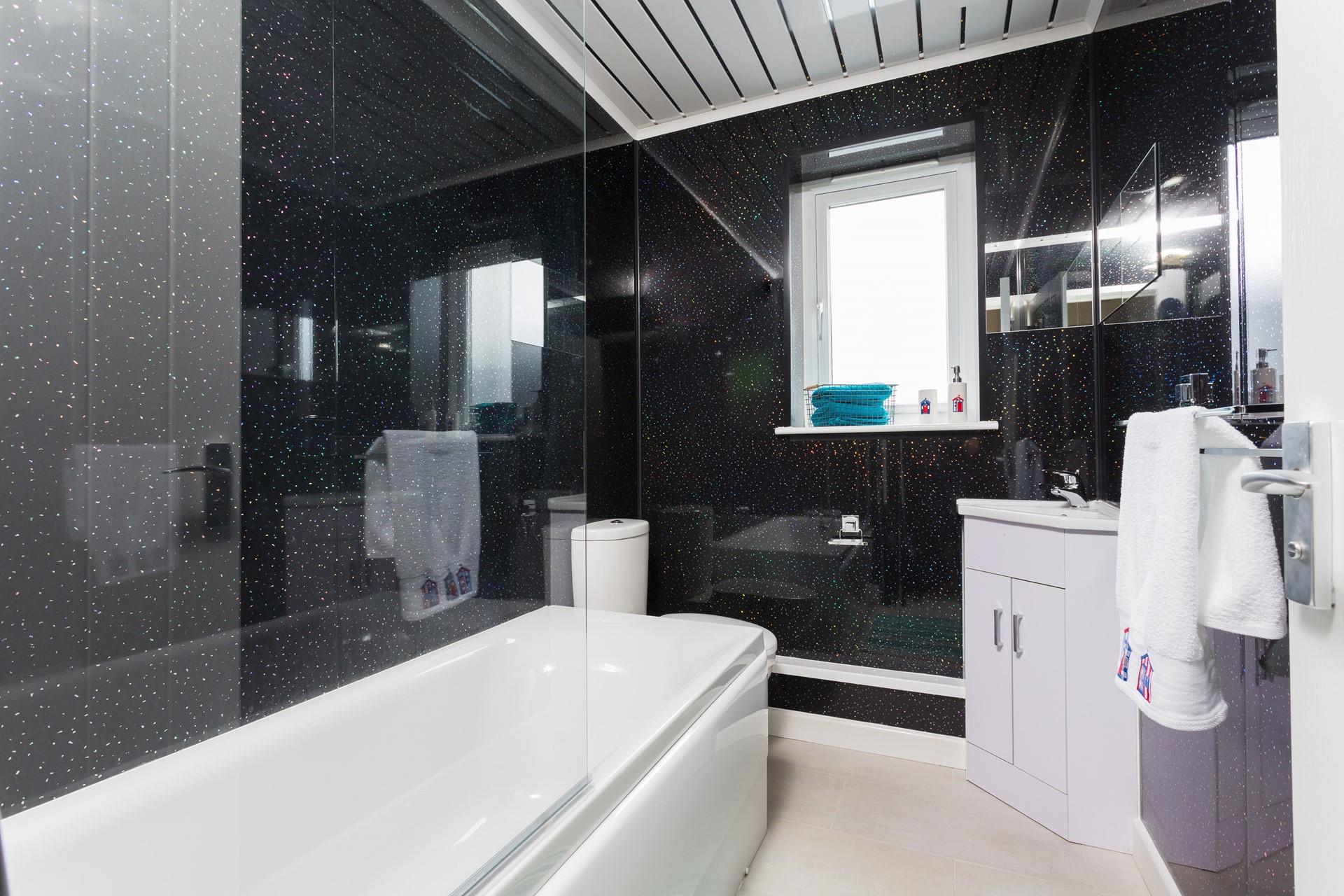Relax in the family bathroom with its bath and shower over and twinkling tiles.