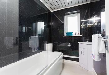 Relax in the family bathroom with its bath and shower over and twinkling tiles.