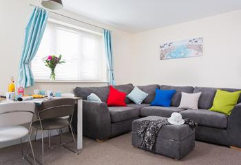 Large windows and a comfy corner sofa give this area a bright and spacious feel.