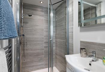 The shower room has a spacious walk-in shower and basin, and is located on the ground floor.