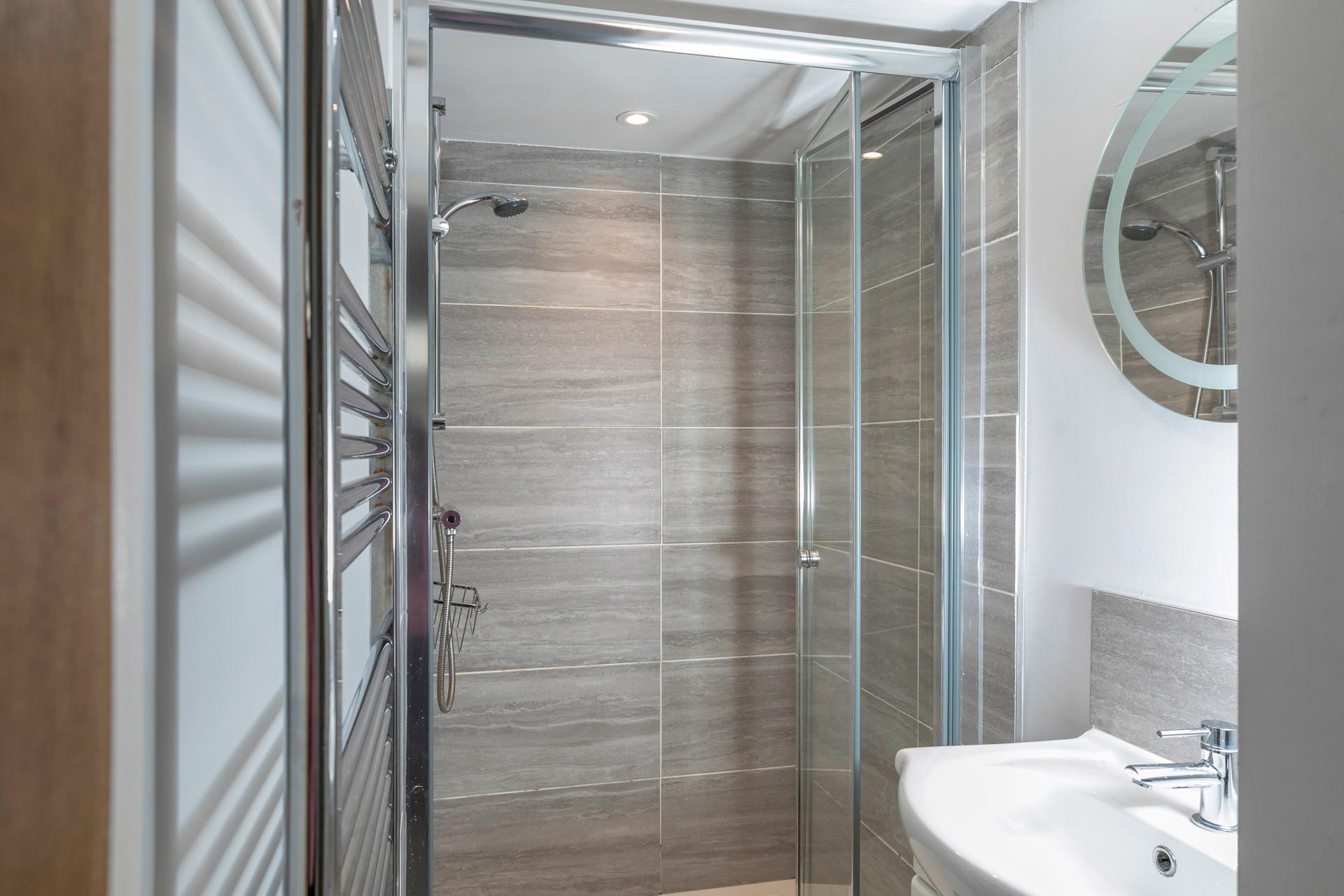 The shower room has a spacious walk-in shower and basin, and is located on the ground floor.