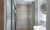 The shower room has a spacious walk-in shower and basin, and is located on the ground floor. - Thumbnail Image
