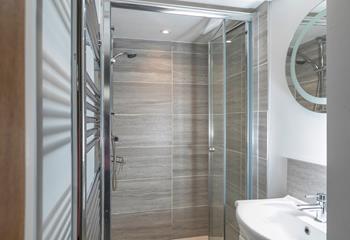 The shower room has a spacious walk-in shower and basin, and is located on the ground floor.