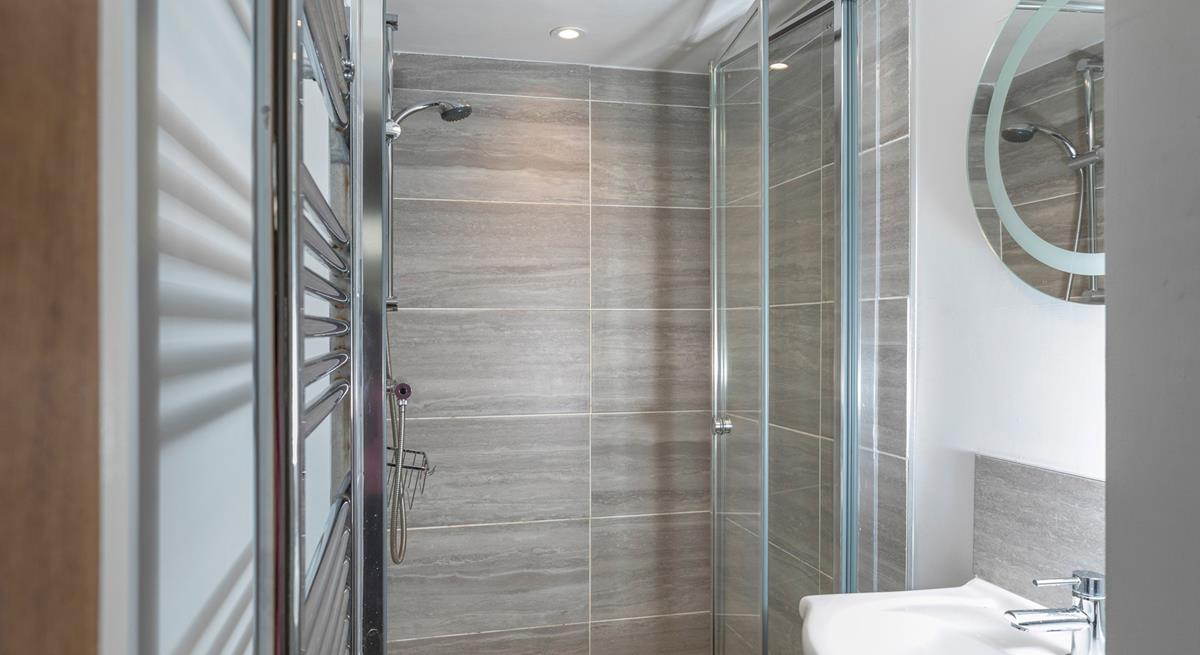 The shower room has a spacious walk-in shower and basin, and is located on the ground floor.