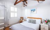 Bedroom 1 has a calming decor and exposed natural wood beams. - Thumbnail Image