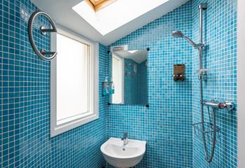 The ground floor wet room is fully tiled in a cool blue mosaic tiling, perfect for washing off sandy toes.