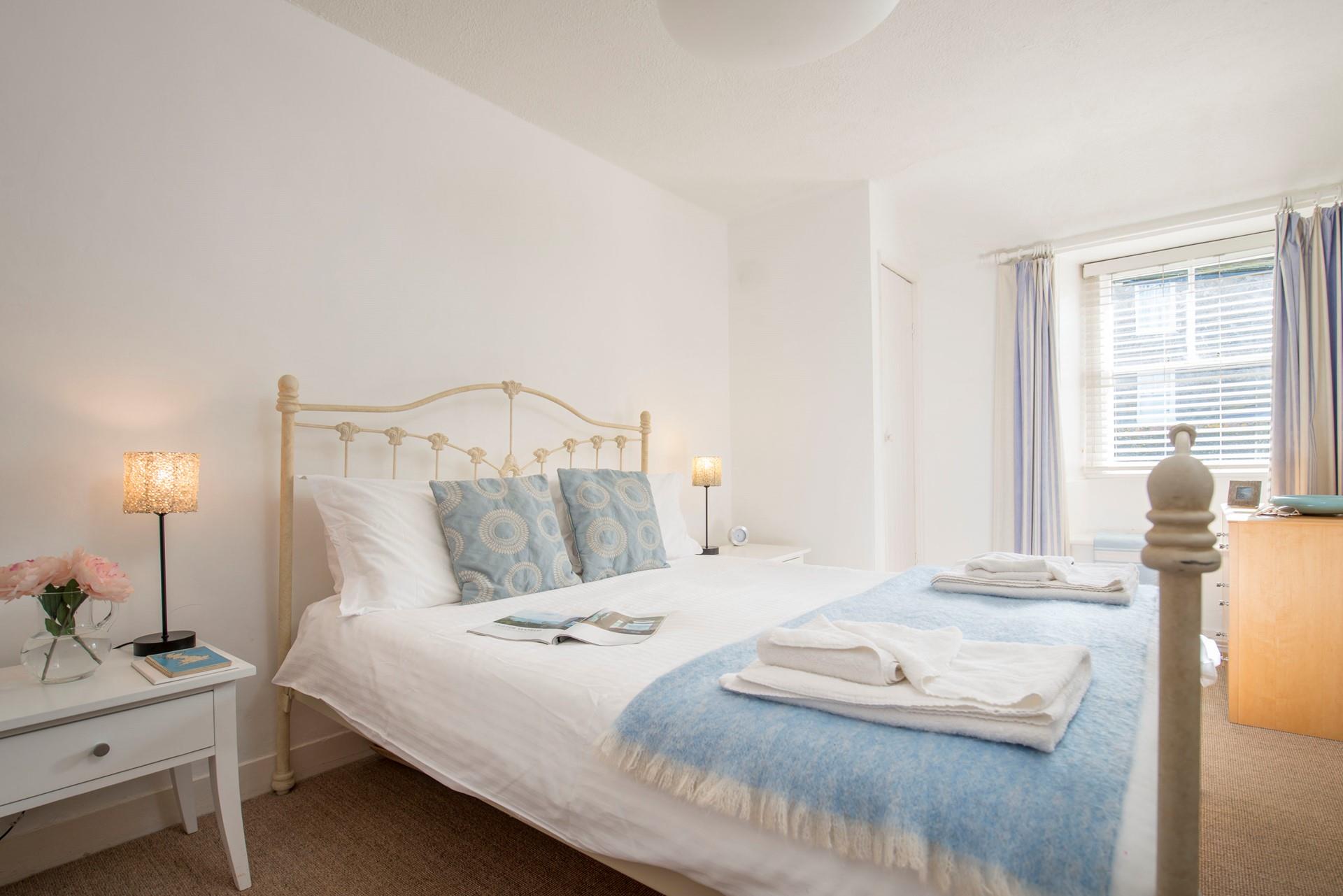 The bedroom has a painted iron-framed king size bed, the quaint bedside tables have a single draw.