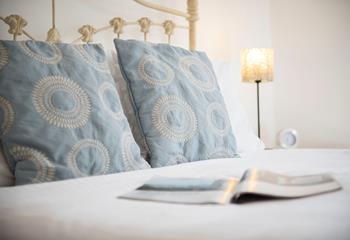 Enjoy restful nights of sleep in this cosy bed, crisp white linen and blue patterned accent cushions. 