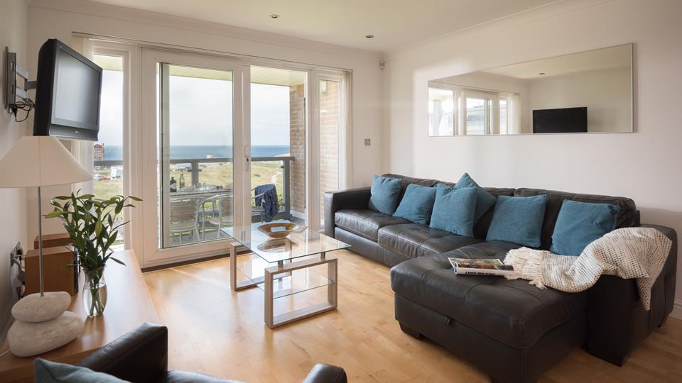 The open plan living area has doors to the balcony which looks out onto the headland beyond. 