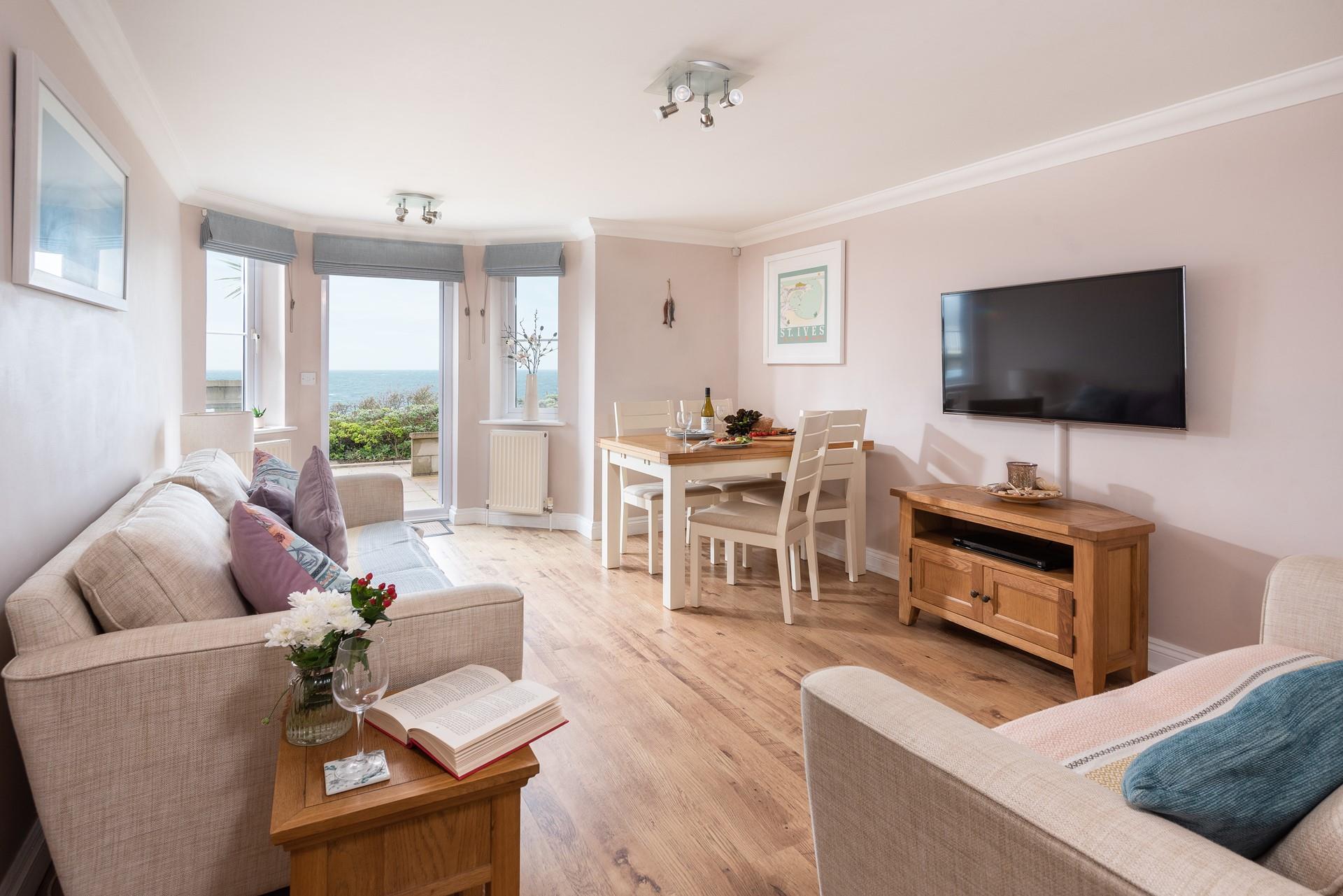 The open plan living area is the perfect place to relax and unwind, whether you're taking in the sea views or catching up with a glass of wine.