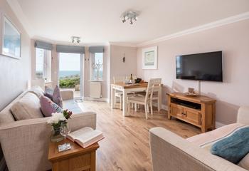The open plan living area is the perfect place to relax and unwind, whether you're taking in the sea views or catching up with a glass of wine.