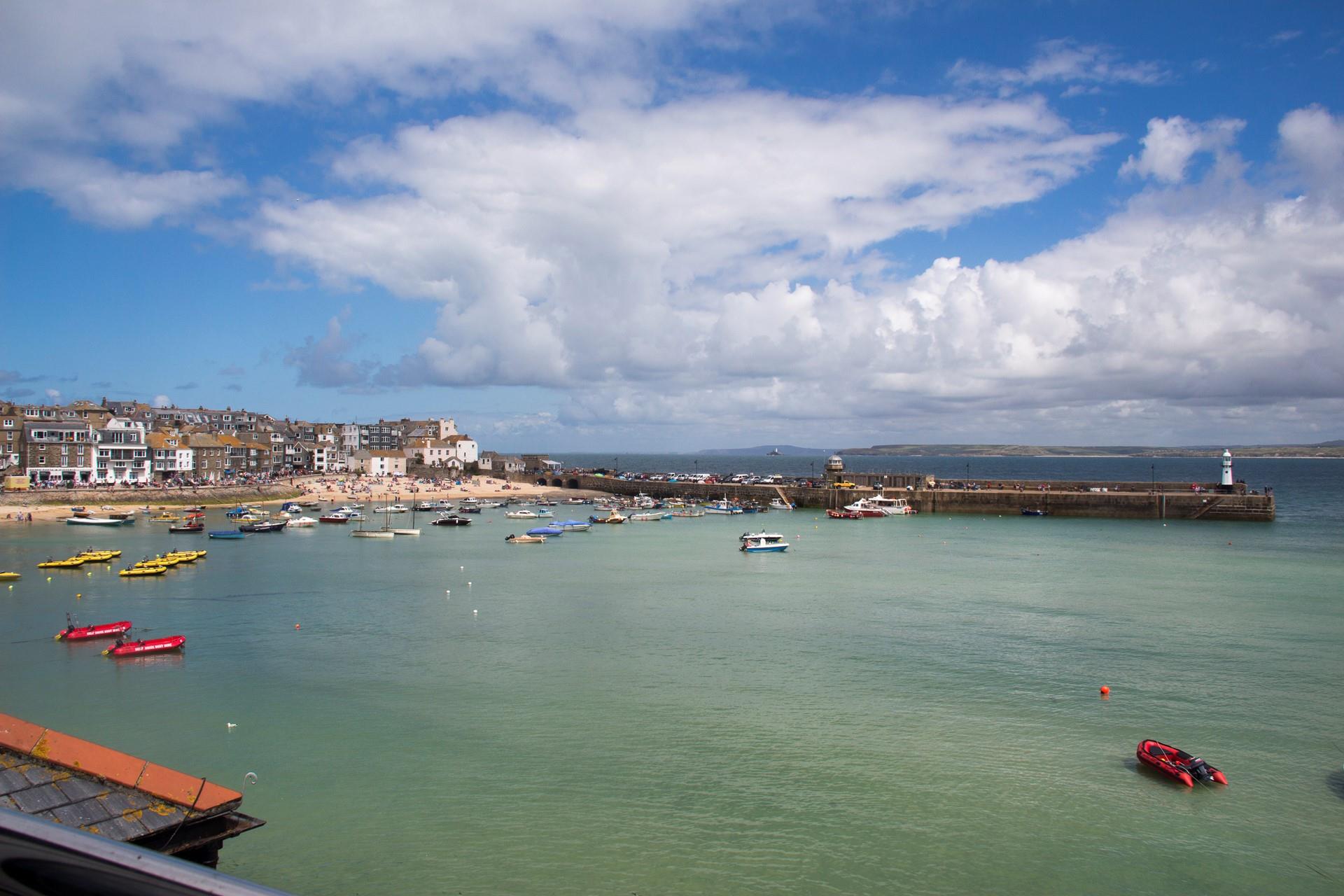 Watch the boats bobbing in the harbour as the sun rises for another beach day.