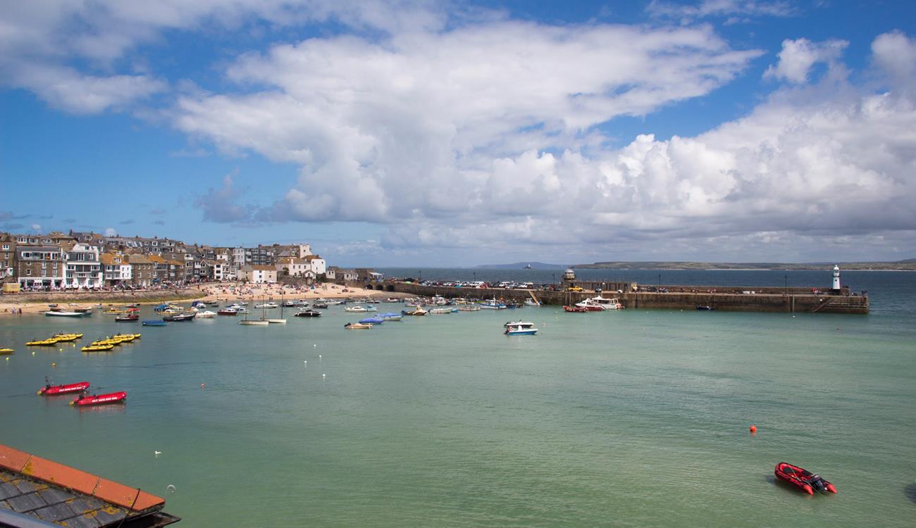Watch the boats bobbing in the harbour as the sun rises for another beach day.