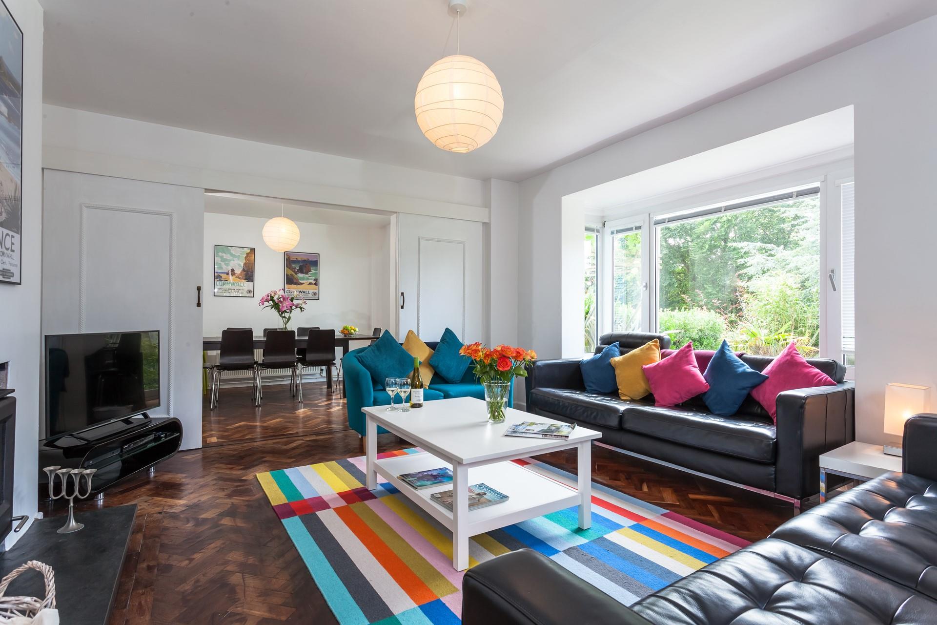 The bright and colour sitting room provides you with a space to relax after a day on the beach.