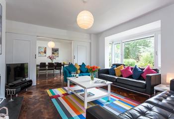 The bright and colour sitting room provides you with a space to relax after a day on the beach.