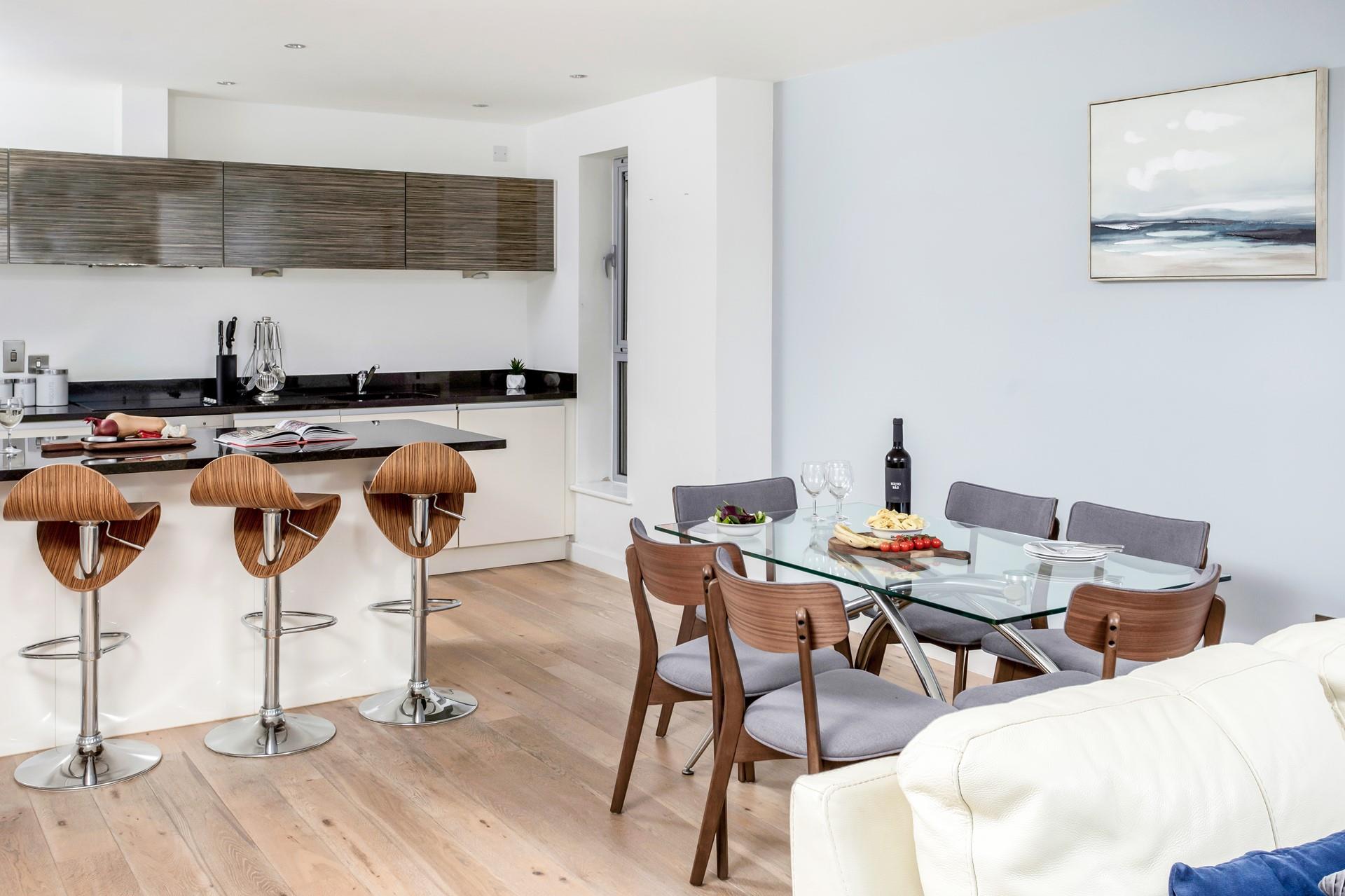 A breakfast bar and a dining table and chairs provide plenty of space for eating and socialising. 