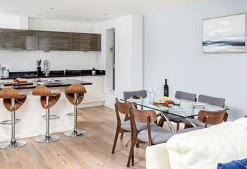 A breakfast bar and a dining table and chairs provide plenty of space for eating and socialising. 