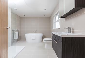 The modern shower room has a deep bath and spacious walk-in shower.