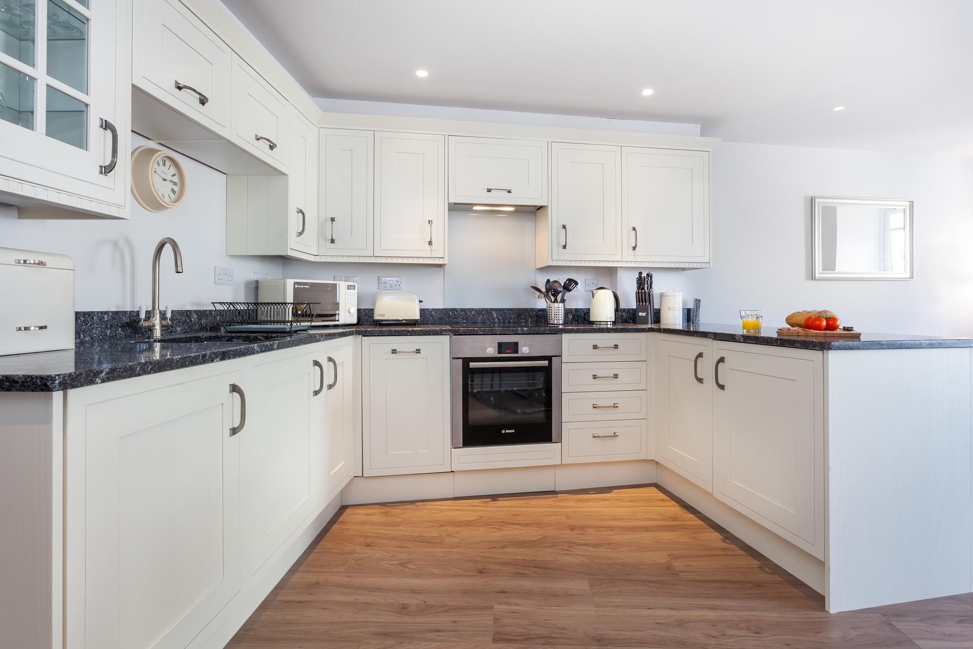 The sleek kitchen is well-equipped and complete with modern appliances. 