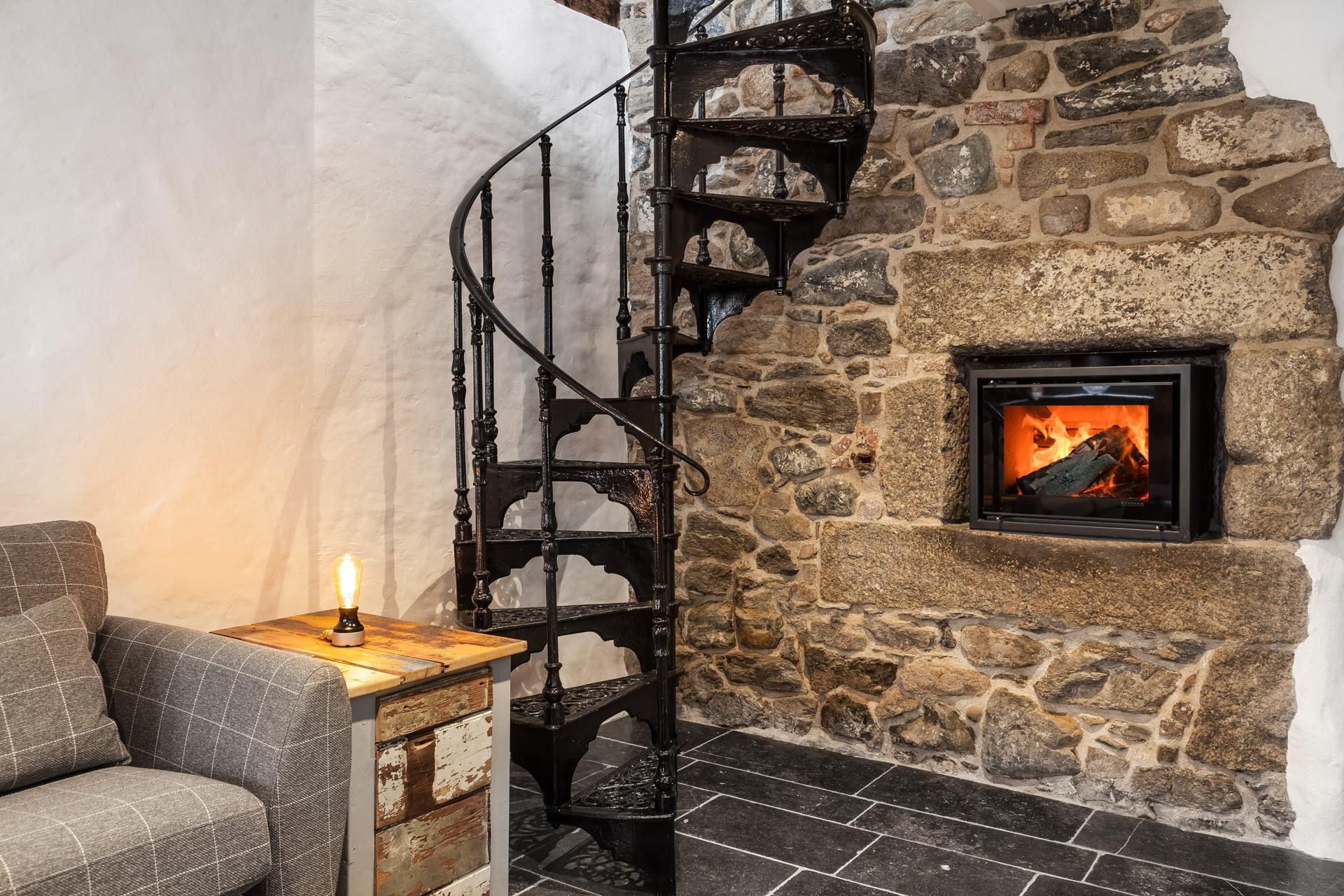 A modern wood burner with exposed stone walls creates a cosy and calming ambience, perfect for snuggly nights in.