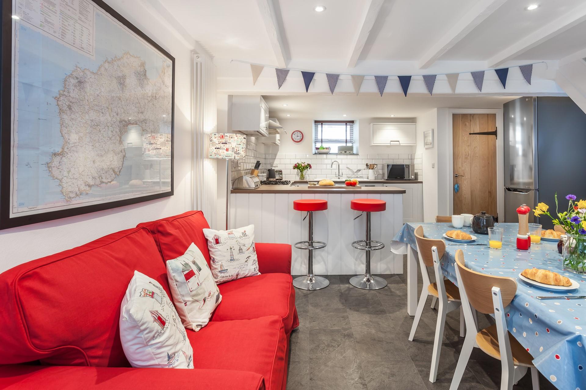 The kitchen/ dining room features a bright sofa and a breakfast bar, space for everyone to have a hearty breakfast.