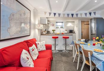 The kitchen/ dining room features a bright sofa and a breakfast bar, space for everyone to have a hearty breakfast.