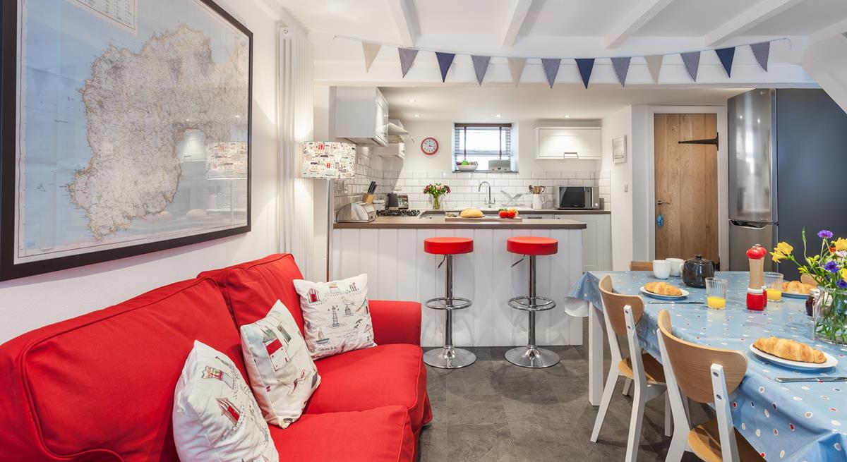 The kitchen/ dining room features a bright sofa and a breakfast bar, space for everyone to have a hearty breakfast.