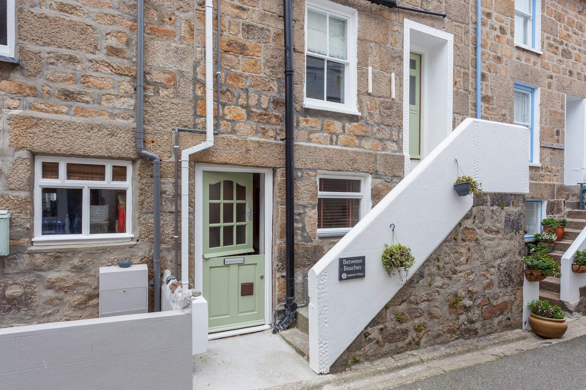 The front of the property. It has a front door on the ground floor, as well as an entrance on the first floor.