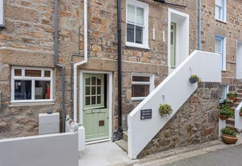 The front of the property. It has a front door on the ground floor, as well as an entrance on the first floor.