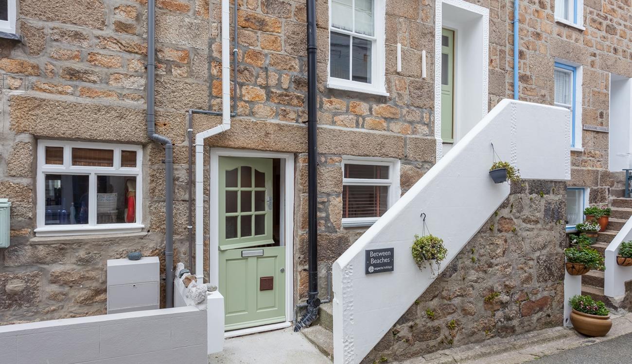 The front of the property. It has a front door on the ground floor, as well as an entrance on the first floor.