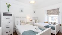 The serene twin bedroom is great for kids of adults.