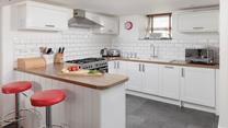 The lovely, modern kitchen area is well-equipped to cook delicious meals.