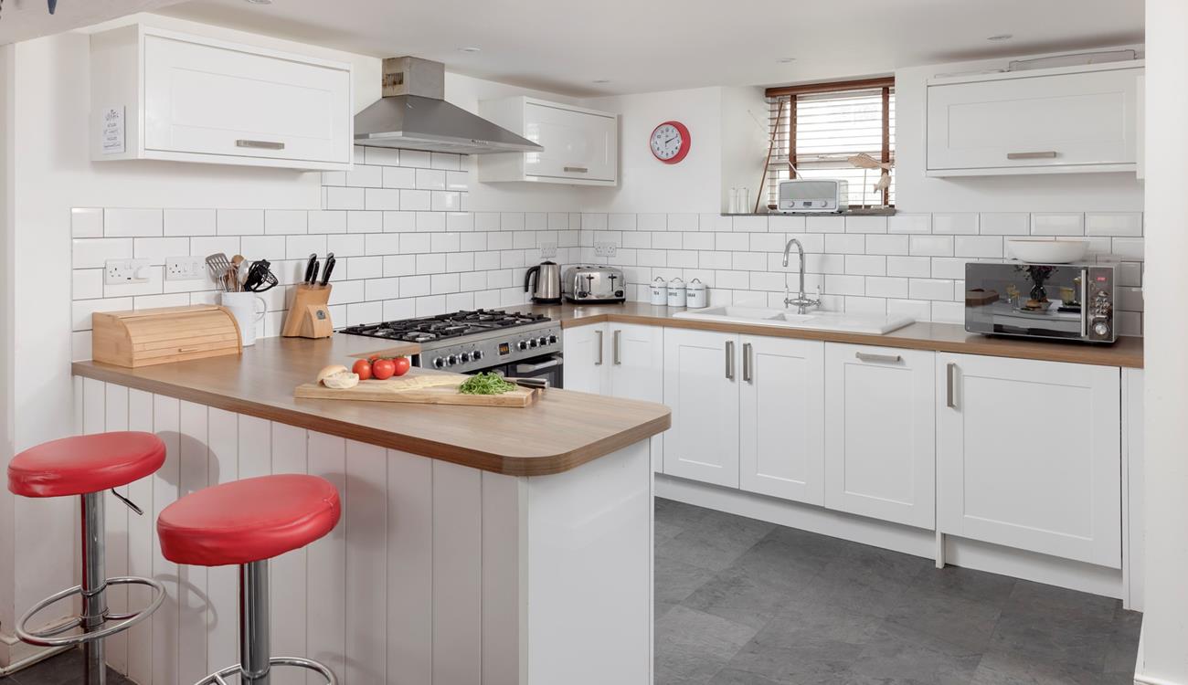 The lovely, modern kitchen area is well-equipped to cook delicious meals.