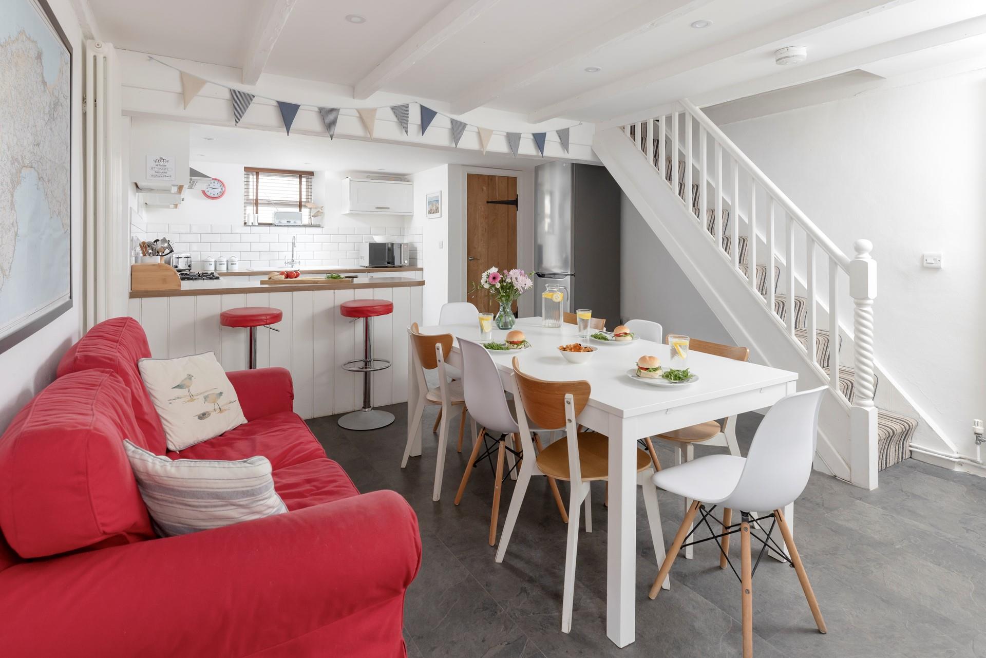 The kitchen/ dining room features a bright sofa and a breakfast bar, space for everyone to have a hearty breakfast.