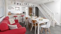 The kitchen/ dining room features a bright sofa and a breakfast bar, space for everyone to have a hearty breakfast.