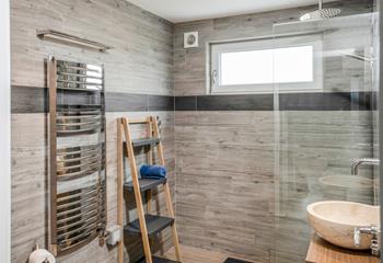 The spacious wet room is modern and stylish, perfect for getting ready in the morning.