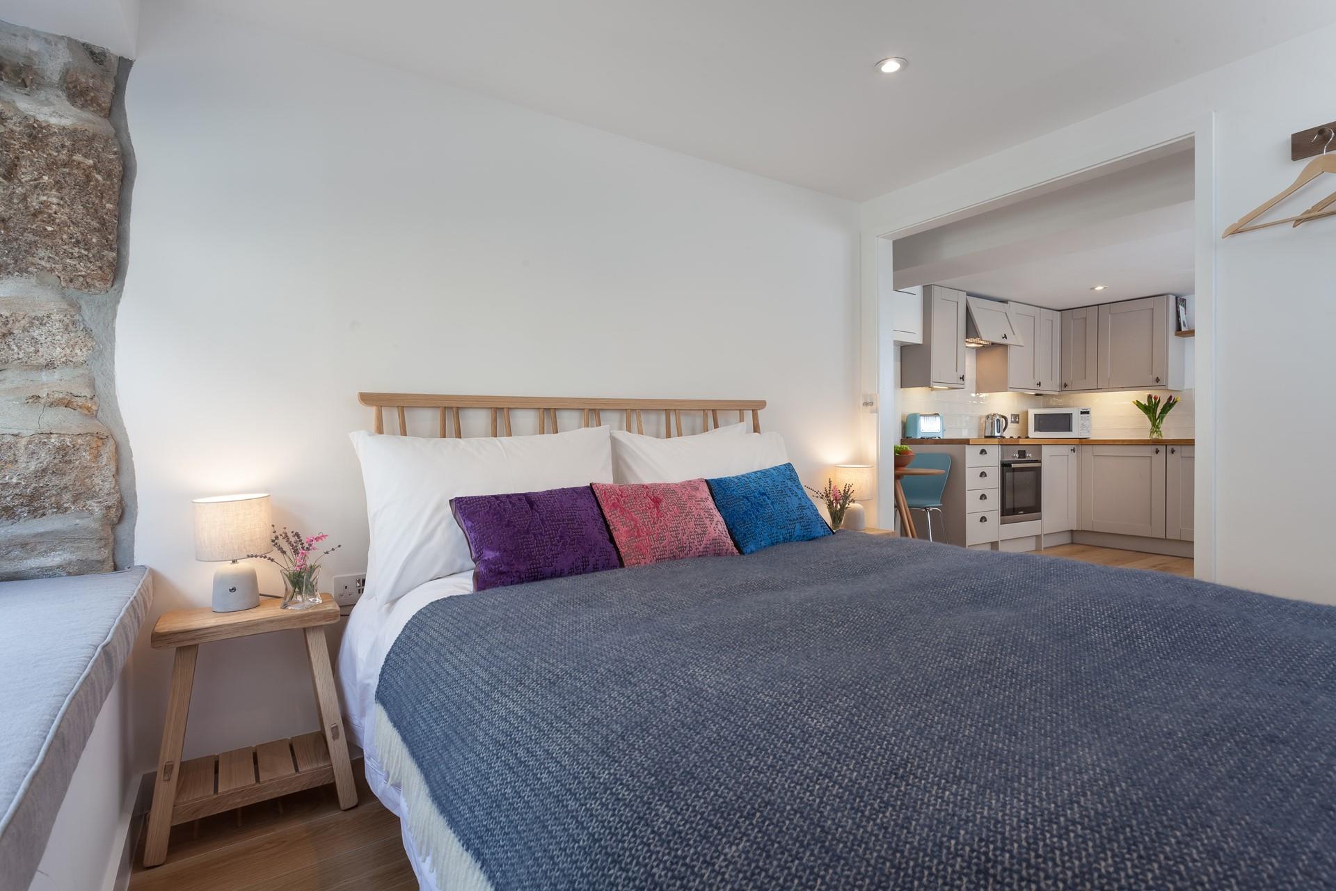 The exposed stone wall gives the bedroom a homely, cottage feel, making it extra welcoming.