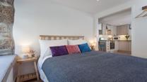 The exposed stone wall gives the bedroom a homely, cottage feel, making it extra welcoming.