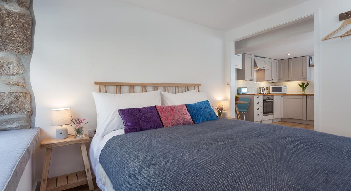 The exposed stone wall gives the bedroom a homely, cottage feel, making it extra welcoming.