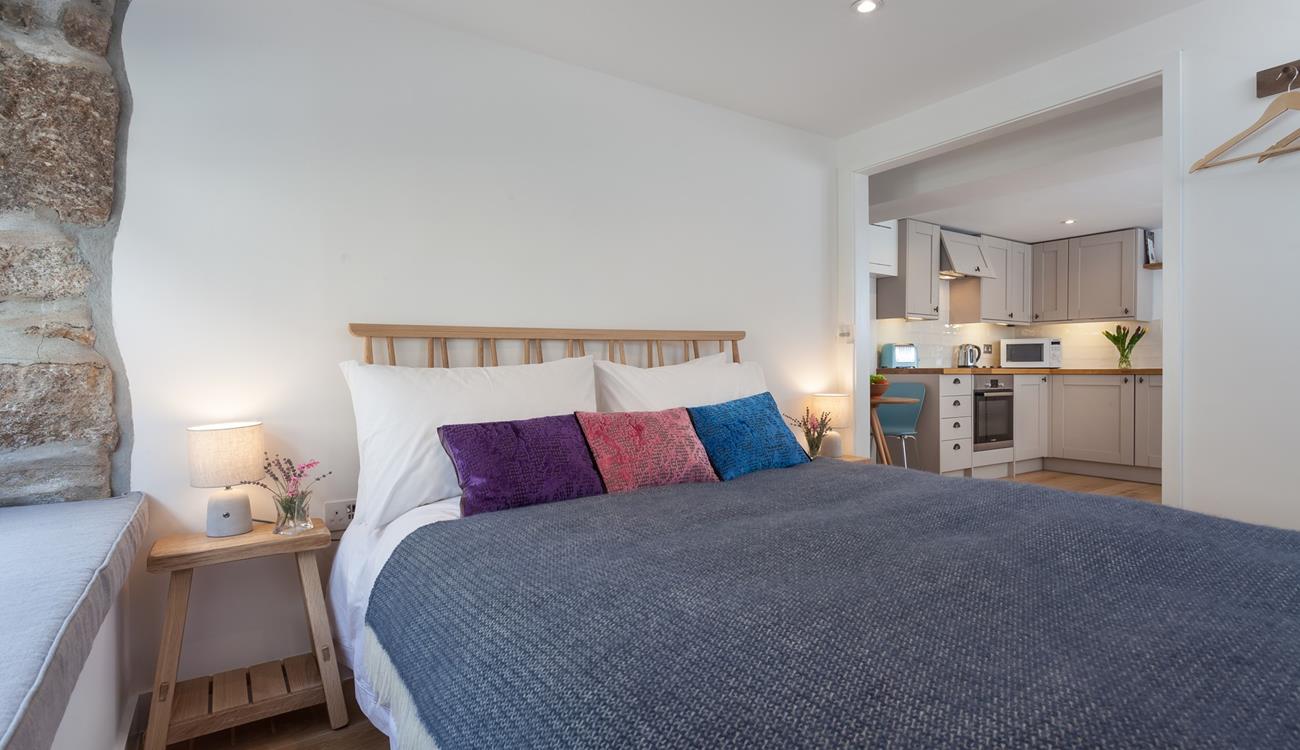 The exposed stone wall gives the bedroom a homely, cottage feel, making it extra welcoming.