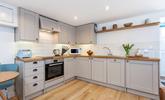 The kitchen's sleek design is sure to delight any budding chef.  - Thumbnail Image