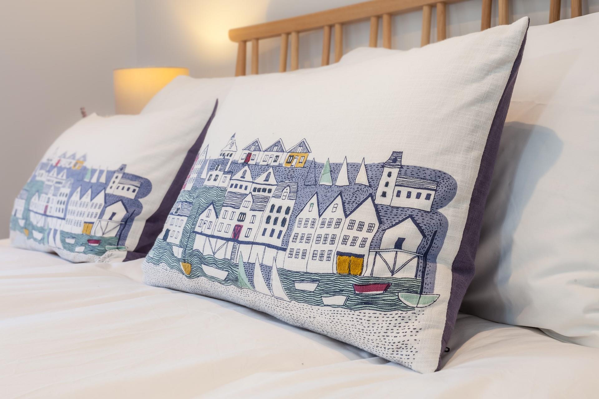 Nautical-themed pillows help continue the seaside theme. 