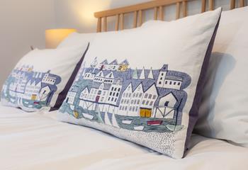 Nautical-themed pillows help continue the seaside theme. 