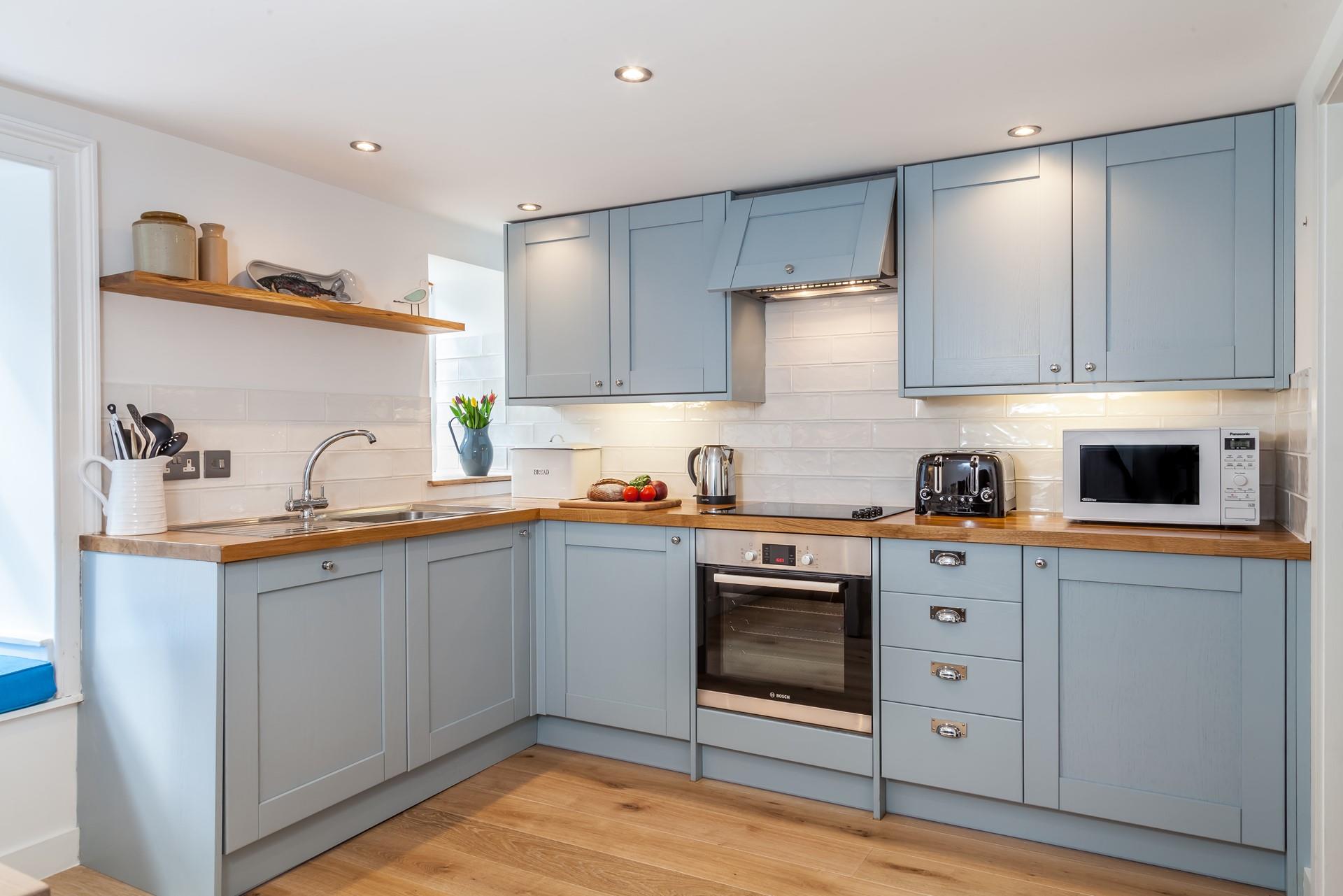 The kitchen is modern and well-equipped with all the appliances you would need to prepare and cook meals.