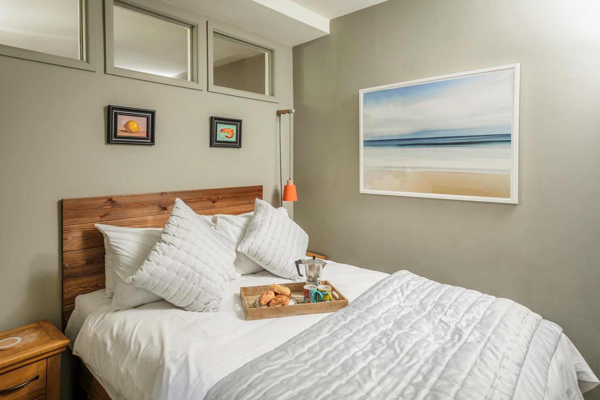 Traditional wooden furniture, crisp linen, and three windows ensure the bedroom is a bright, welcoming space.