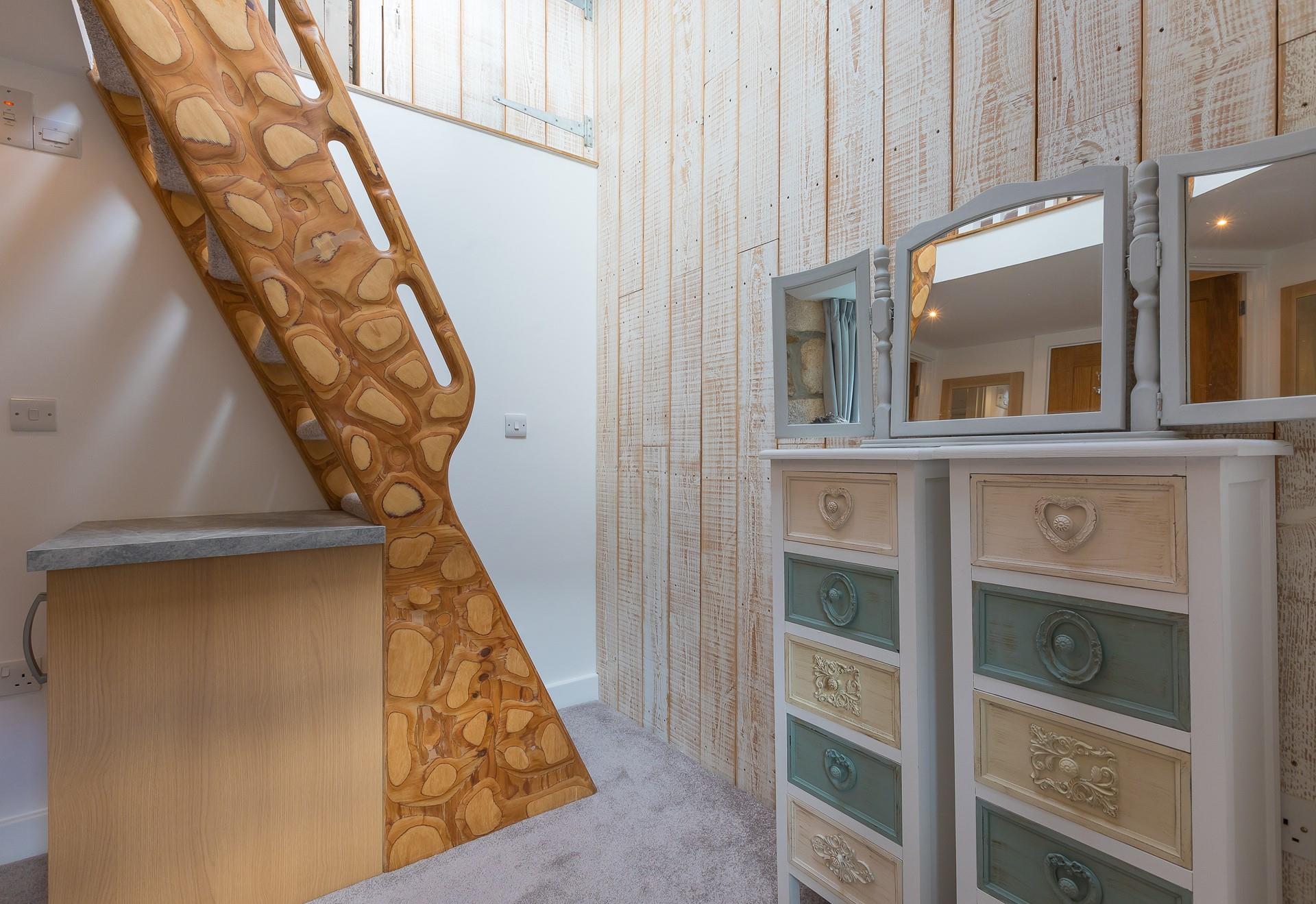 The unique handmade ladder steps lead to the mezzanine level double bedroom. 