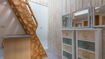 The unique handmade ladder steps lead to the mezzanine level double bedroom. 