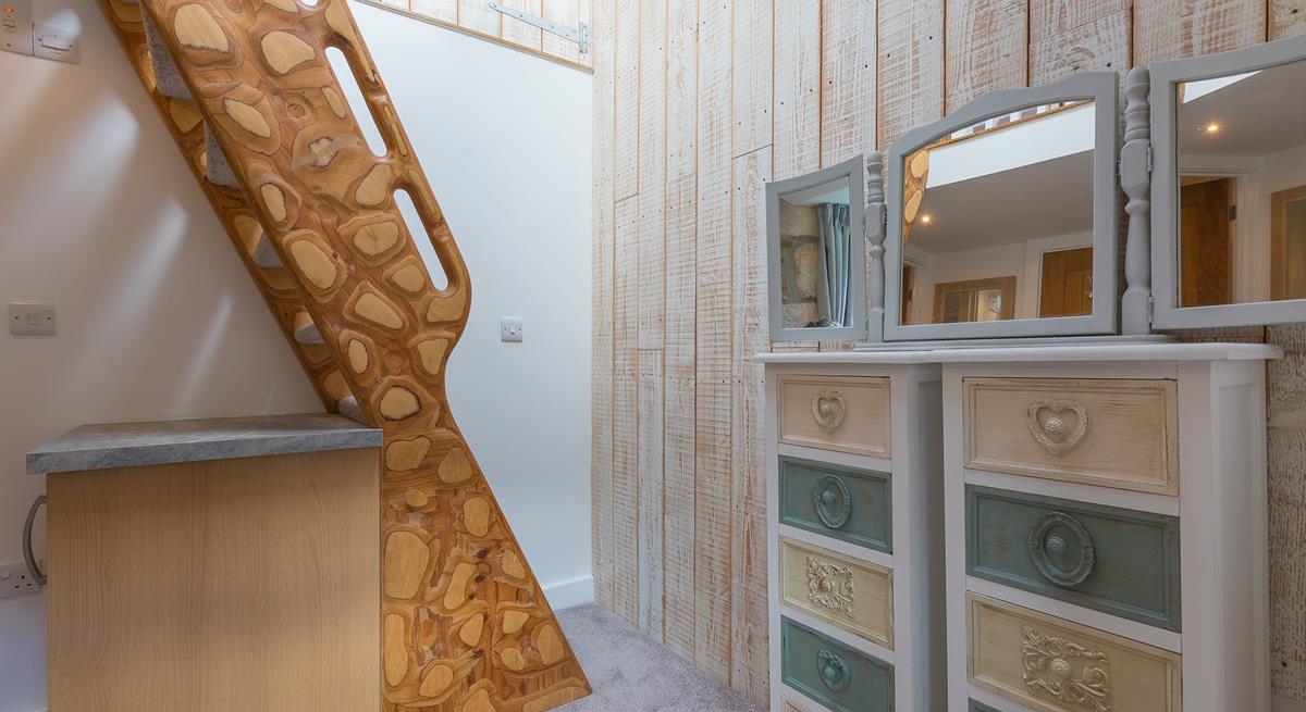 The unique handmade ladder steps lead to the mezzanine level double bedroom. 