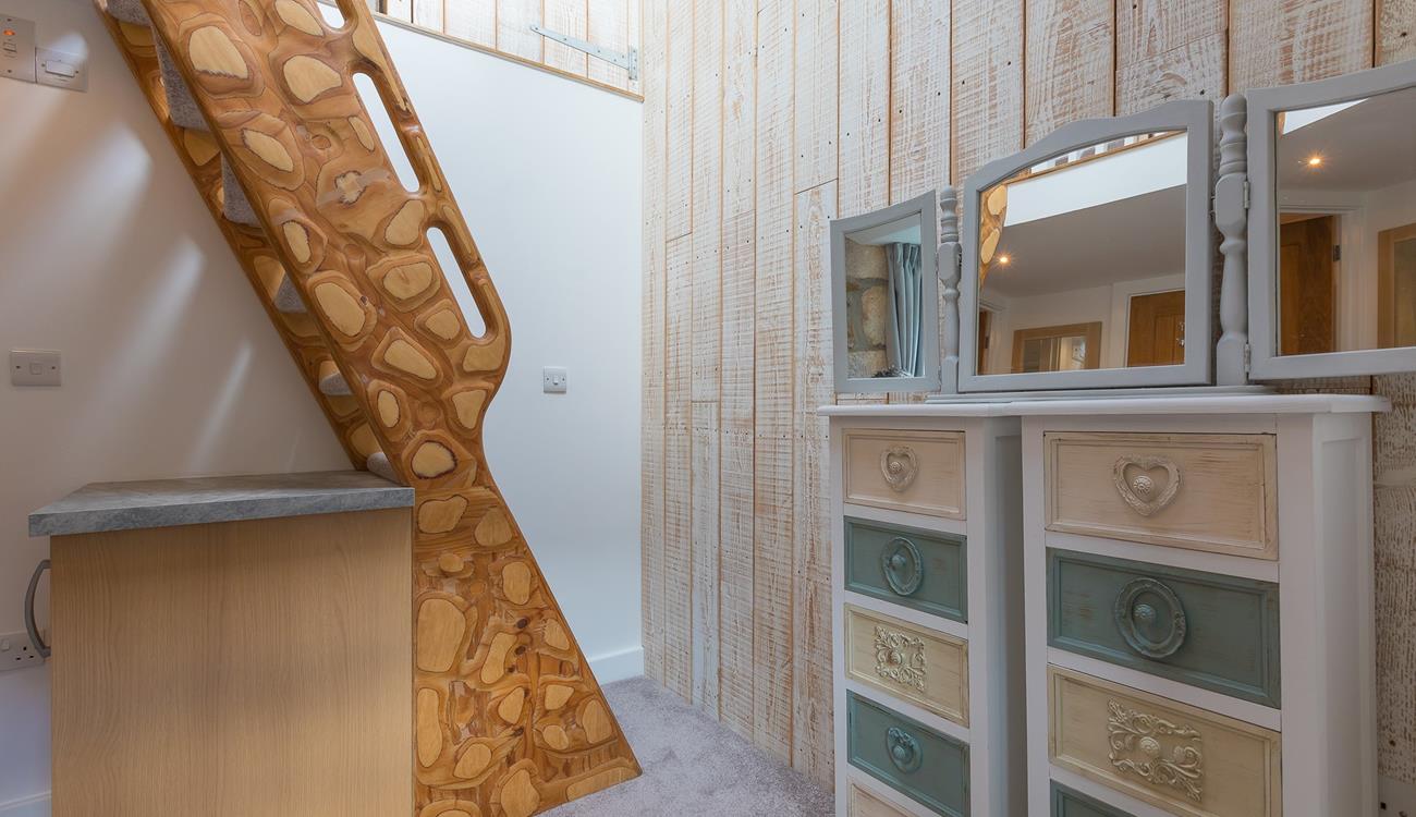 The unique handmade ladder steps lead to the mezzanine level double bedroom. 