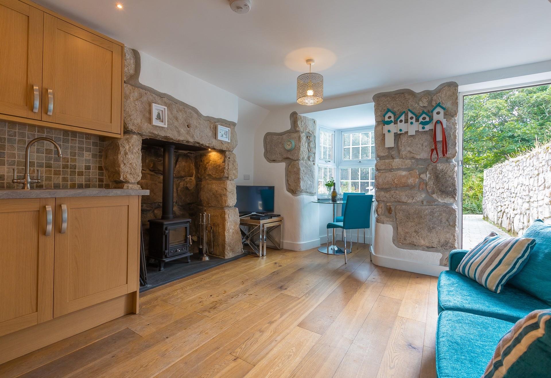 The Cornish granite inglenook fireplace features a woodburner, perfect for those cooler evenings. 